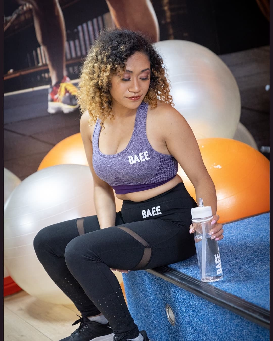 Model wearing black legging with purple womens sports bra